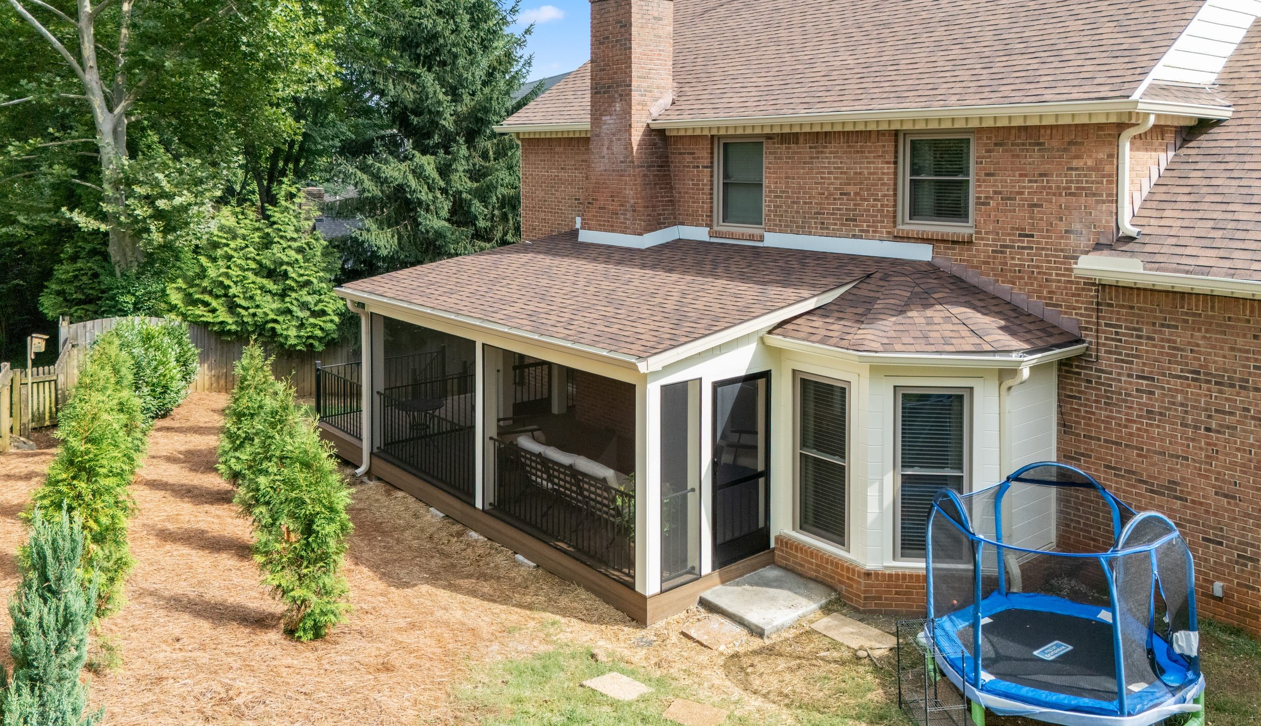 Elevated view of the Ashgrove porch roof tying into the brick home's existing shingle roofline