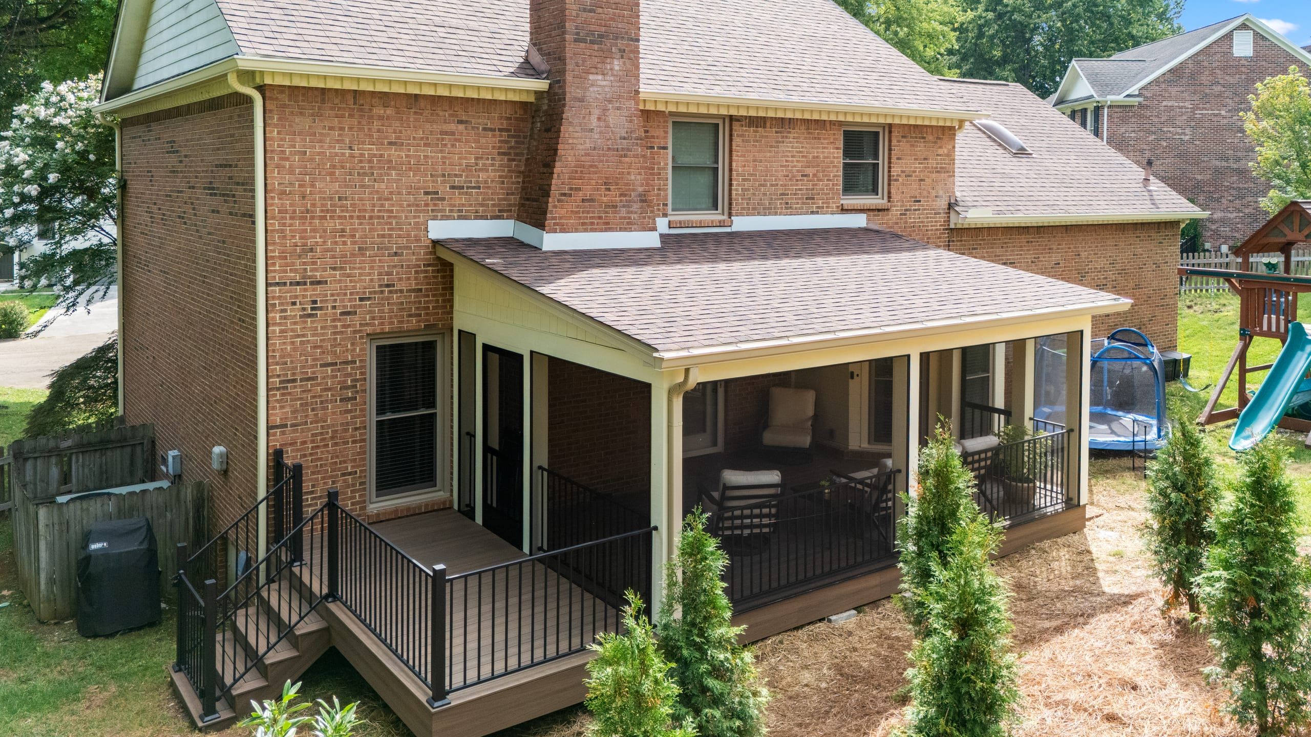 Aerial view of the Ashgrove brick home with its screened porch addition and open Trex deck