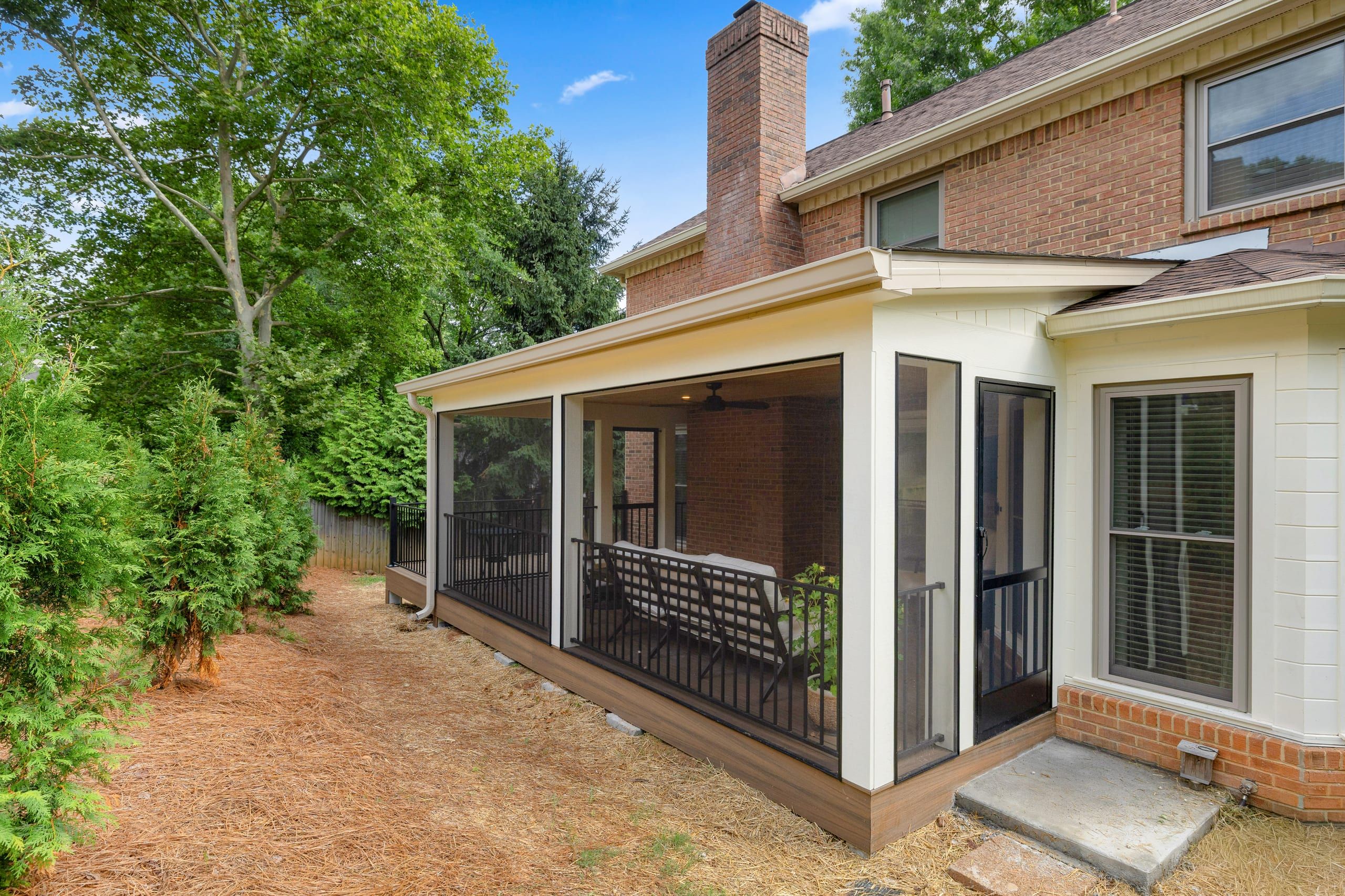Side view of the Ashgrove screened porch addition showing the full-height screen panels and a screen door