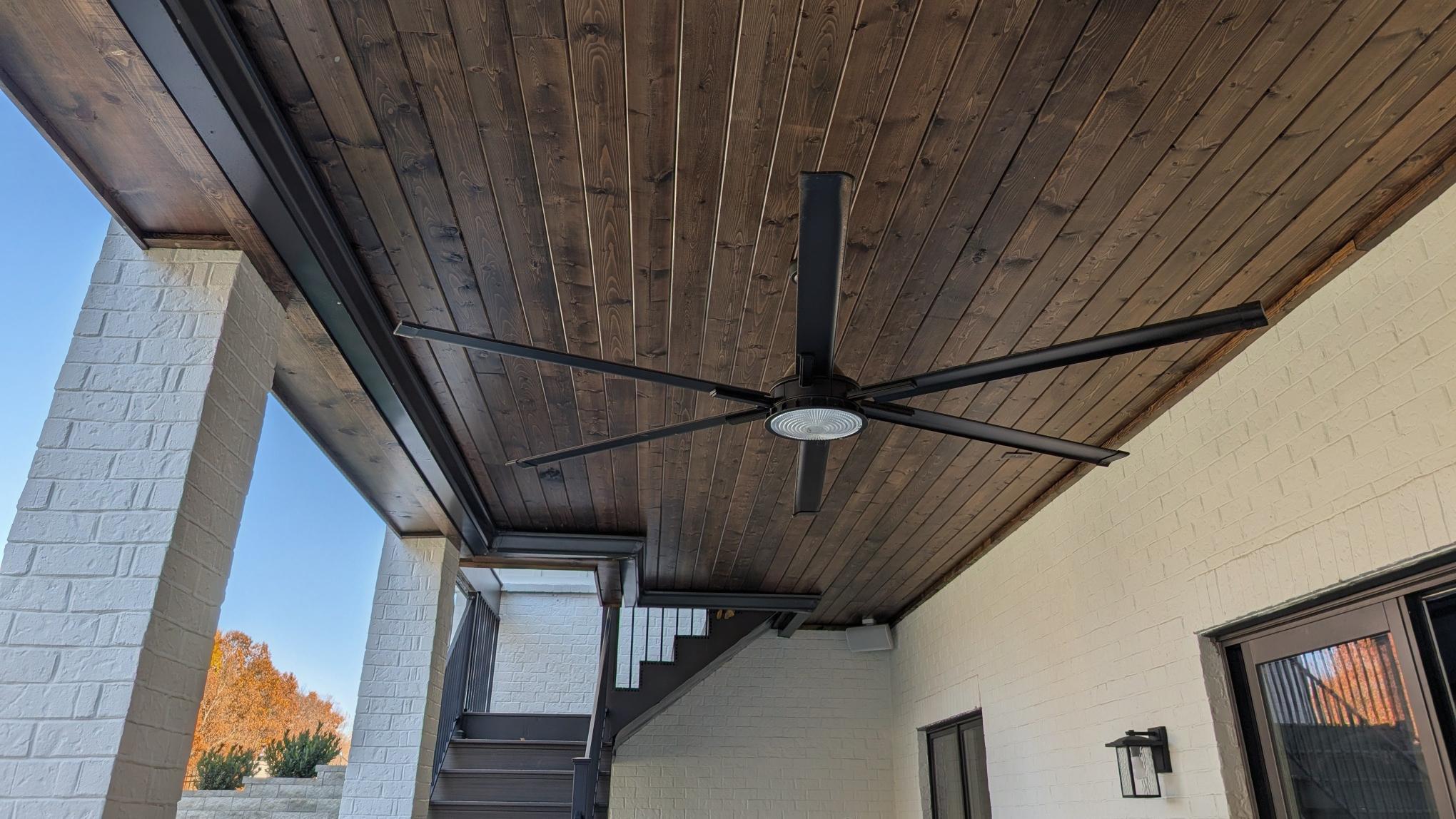 Finished under-deck patio with waterproof T&G ceiling, brick columns, and black ceiling fan