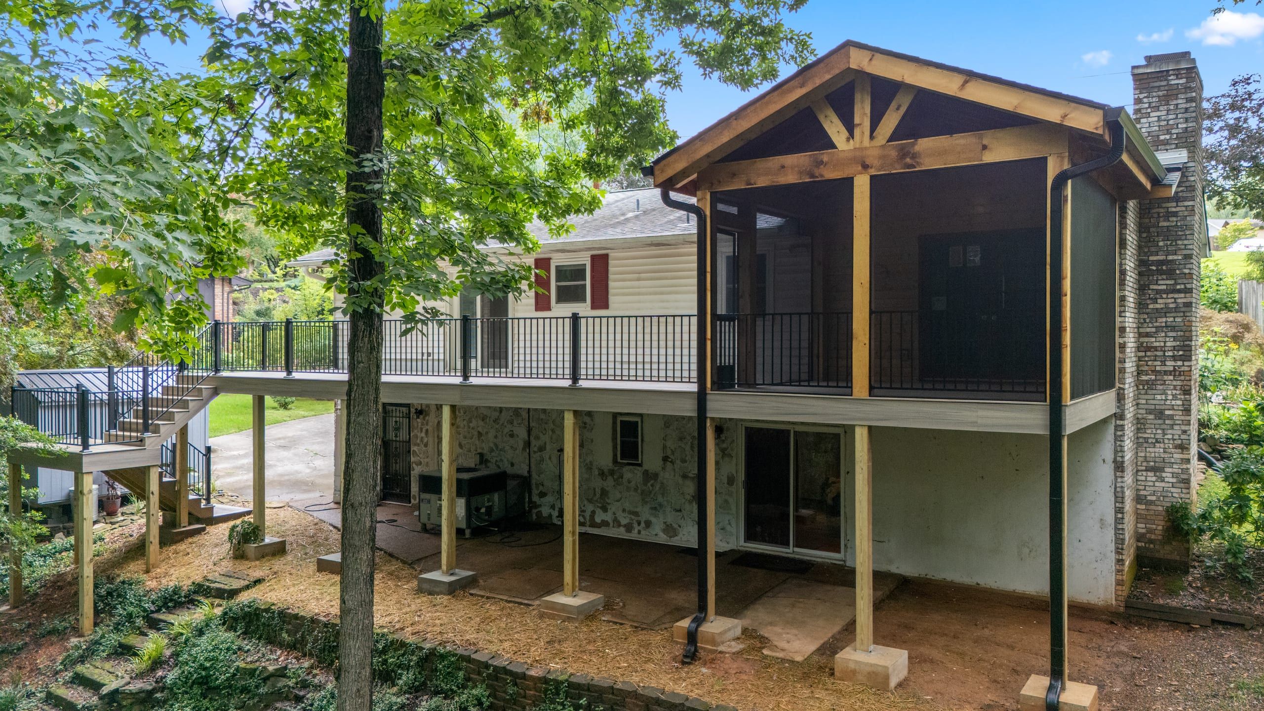 Rear elevation of the Venice home showing the gable-roofed screened porch, elevated deck, and brick chimney