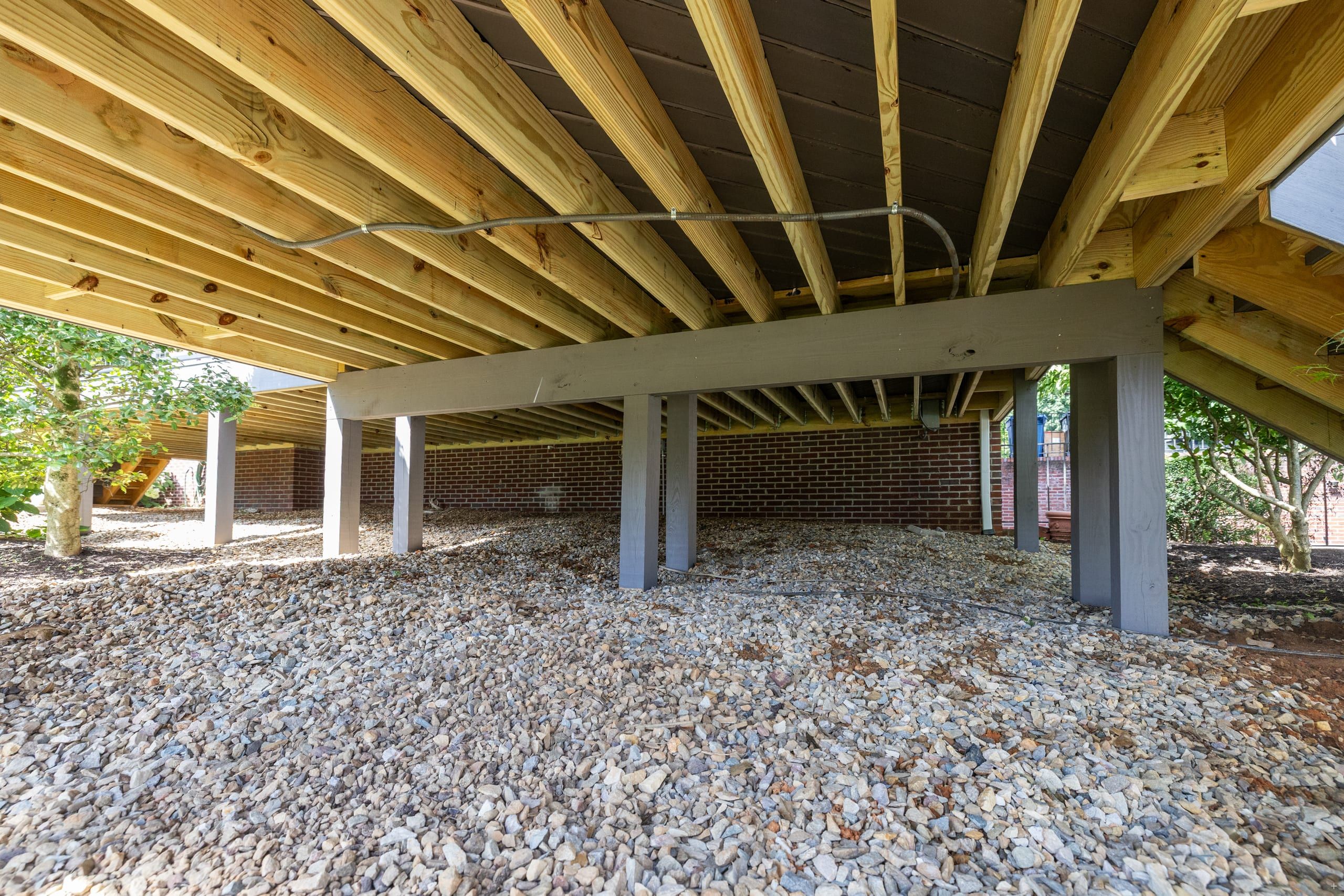 Under the Wilshire deck showing engineered pressure-treated joists and painted posts over a stone bed